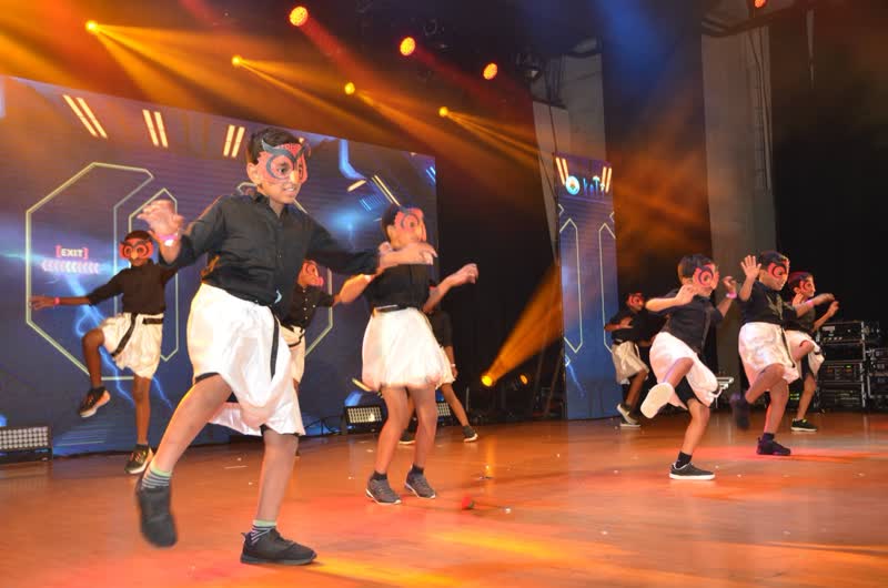 Students dancing on a colourfully lit stage