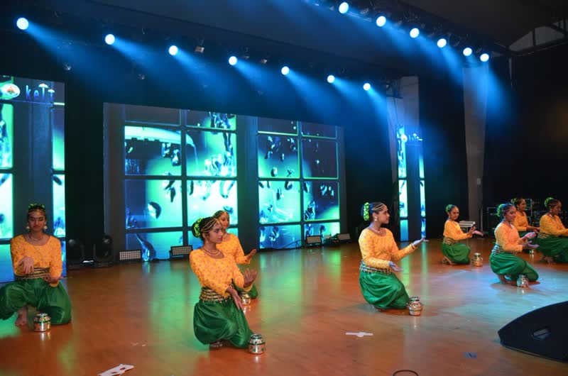A group dance performance under stage lights
