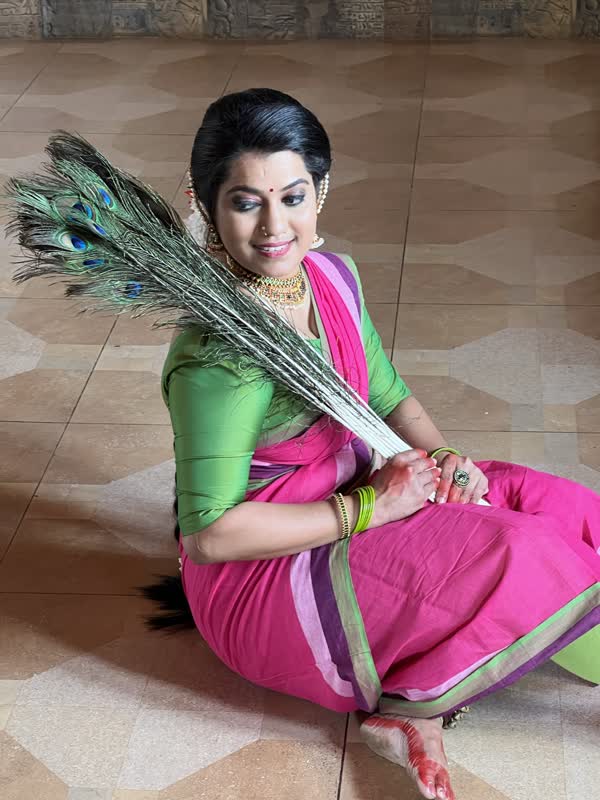 Dancer holding peacock feathers