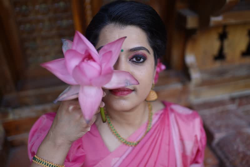 Close-up of a dancer holding a pink lotus
