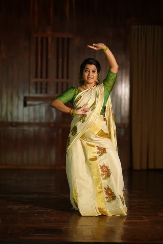 A dancer in a cream and gold Mohiniyattam costume